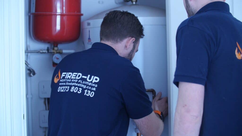 Professional UK plumbers standing together in work clothing